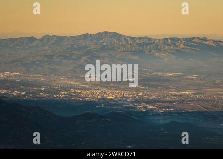 Vue aérienne de la ville d'Amposta au coucher du soleil. En arrière-plan, la chaîne de montagnes Cardó (Tarragone, Catalogne, Espagne) Banque D'Images