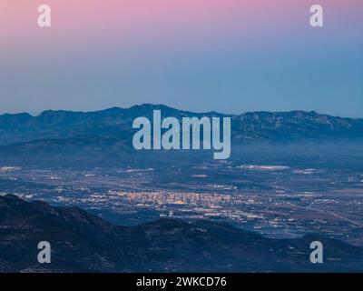 Vue aérienne de la ville d'Amposta au coucher du soleil. En arrière-plan, la chaîne de montagnes Cardó (Tarragone, Catalogne, Espagne) Banque D'Images