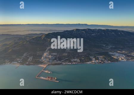 Vue aérienne de la chaîne de montagnes Montsià et du port industriel d'Alcanar sur un coucher de soleil hivernal (Tarragone, Catalogne, Espagne) Banque D'Images