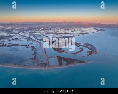 Lever de soleil sur l'embouchure de l'Èbre dans le delta de l'Èbre avec la pleine Lune à l'horizon. Vue aérienne (Delta de l'Èbre, Tarragone, Catalogne, Espagne) Banque D'Images