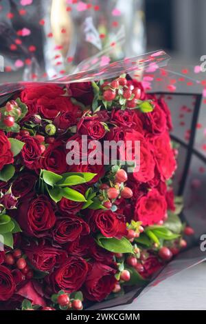 Fond festif de bouquet de roses rouges avec des éléments en or et une boîte-cadeau, modèle bannière de carte de voeux pour les souhaits festifs de la Saint-Valentin et la journée des femmes Banque D'Images