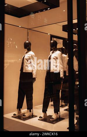 Mannequins élégants noirs dans une vitrine de boutique habillés d'une veste blanche et d'un pantalon Banque D'Images