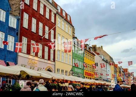 Des maisons vibrantes bordent la rue tandis qu'une foule se promène à Copenhague, au Danemark Banque D'Images