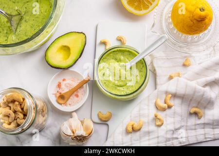 Vinaigrette au yaourt à l'avocat maison avec des ingrédients sur la table de cuisine Banque D'Images