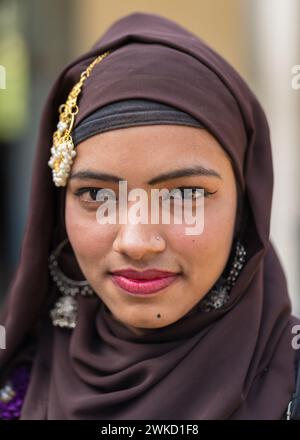 Gros plan portrait d'une jeune femme musulmane attrayante portant un foulard brun, des bijoux et du rouge à lèvres Banque D'Images