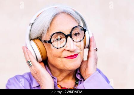 femme âgée souriante appréciant écouter de la musique Banque D'Images