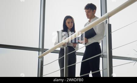 Femme d'affaires caucasienne et homme d'affaires discutent des documents dans le hall d'entreprise hommes et femmes hommes d'affaires femmes et hommes collègues partenaires collègues Banque D'Images