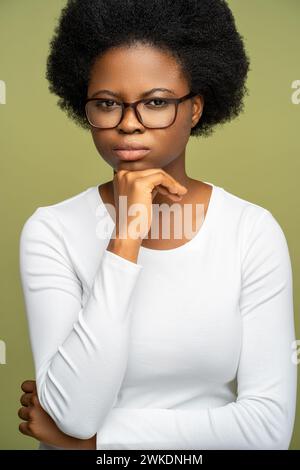 Auto assuré femme afro-américaine intelligente dans des lunettes regardant la caméra avec un regard strict. Banque D'Images