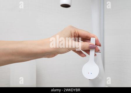 l'homme ouvre le robinet d'eau dans la cuisine. l'homme allume l'eau. main tourne la poignée d'un robinet de cuisine. à l'aide d'un robinet de cuisine Banque D'Images