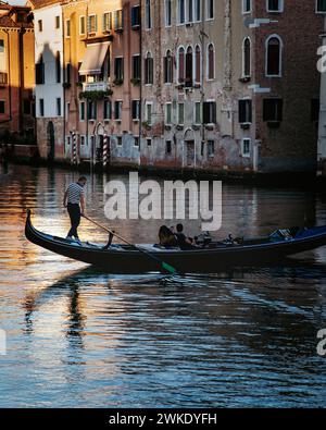 Un couple profite d'une balade en gondole sur l'un des nombreux petits canaux latéraux de la ville historique de Venise, en Italie. Banque D'Images