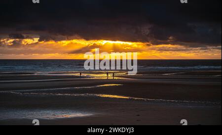 Les derniers rayons de soleil venant à travers les nuages sur la plage de Blackpool Banque D'Images