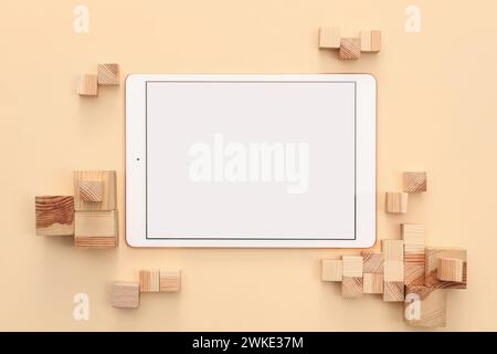 Tablette moderne et cubes en bois sur fond beige, pose à plat. Espace pour le texte Banque D'Images