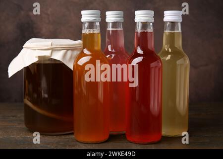 Délicieux kombucha dans des bouteilles en verre et pot sur une table en bois Banque D'Images