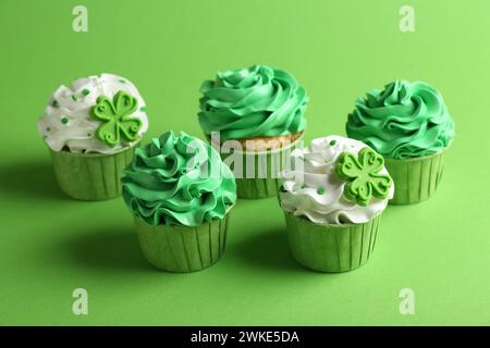 Prog Fête de Patrick. Savoureux cupcakes décorés de façon festive sur fond vert Banque D'Images