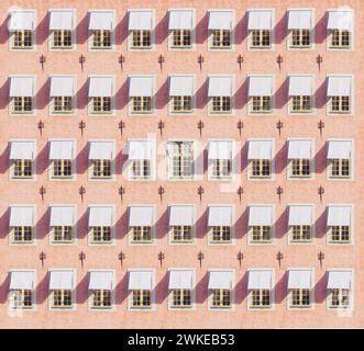 Façade rose du bâtiment. Vieilles fenêtres avec visières. Style rétro. Minimalisme. Concept d'être unique. Banque D'Images