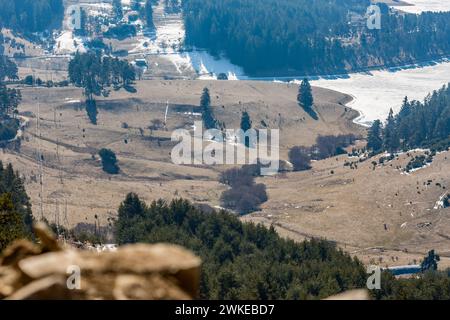 Perspective élevée du réservoir d'eau Dospat et de la ville dans le sud de la Bulgarie, eau gelée, neige couverte de montagnes Rhodope en hiver Banque D'Images