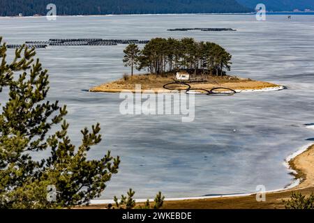 Perspective élevée du réservoir d'eau Dospat et de la ville dans le sud de la Bulgarie, eau gelée, neige couverte de montagnes Rhodope en hiver Banque D'Images