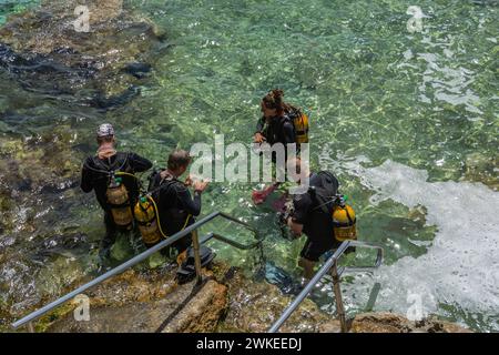 Cirkewwa, Malte - 19 juillet 2018 : plongeurs debout dans la mer se préparant à une plongée. Banque D'Images