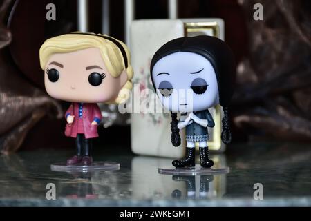 Funko Pop figurines de Sabrina Spellman sorcière et Wednesday Addams. Colonnes, sombre, crypte, cercueil blanc ouvert, effrayant, gothique, plancher de réflexion. Banque D'Images