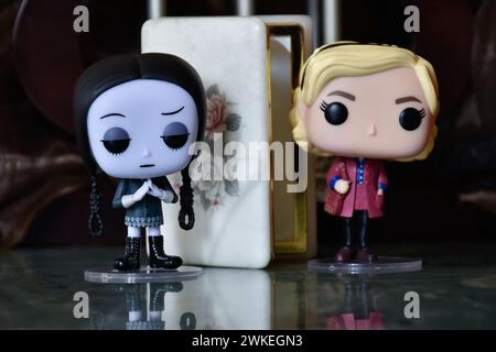 Funko Pop figurines de mercredi Addams et Sabrina Spellman sorcière. Colonnes, sombre, crypte, cercueil blanc ouvert, effrayant, gothique, plancher de réflexion. Banque D'Images