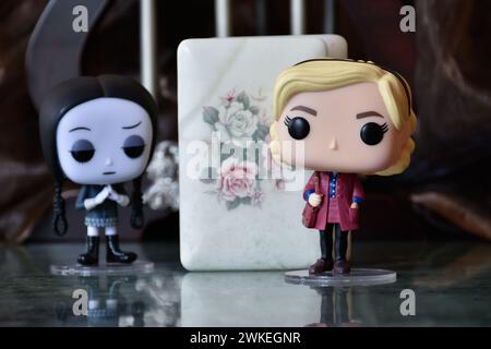 Funko Pop figurines de mercredi Addams et Sabrina Spellman sorcière. Colonnes, sombre, crypte, cercueil blanc ouvert, effrayant, gothique, plancher de réflexion. Banque D'Images