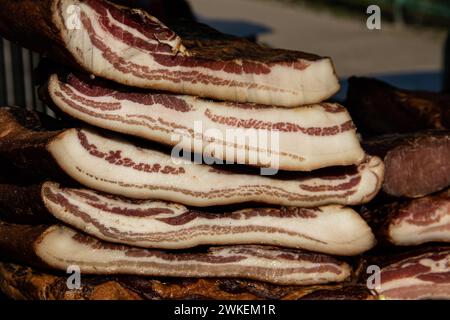 Bacon exposé et viande séchée produits domestiques présentés à la vente sur un marché fermier dans le village de Kacarevo, gastro bacon et viande sèche festival Banque D'Images