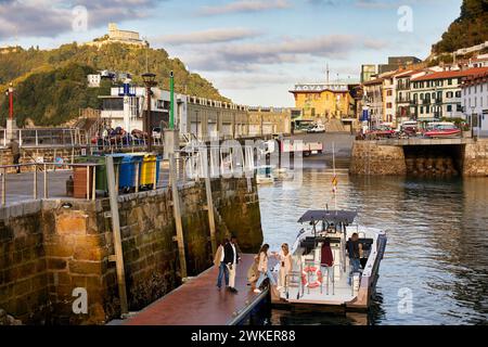 Bateau pour les promenades touristiques dans le port de Donostia, en arrière-plan l'Aquarium et le mont Igeldo, Saint-Sébastien, pays Basque, Espagne Banque D'Images