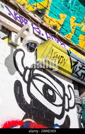 Caméra CCTV entourée de graffitis et d'œuvres d'art de rue dans le tunnel de Leake Street, Londres. Banque D'Images