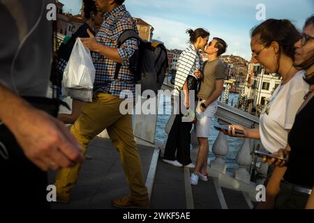 Les gens viennent aux ponts sur Venise pour être vus et admirer le coucher du soleil. Un jeune couple amoureux sur un pont sur le Grand canal. Banque D'Images