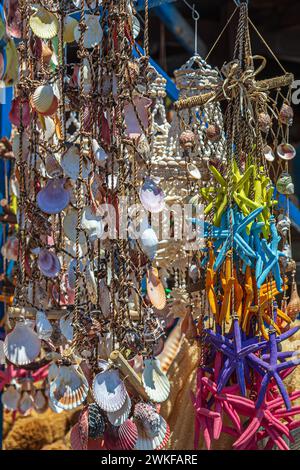 Fond avec des coquillages ornementaux et des souvenirs accrochés à un filet sur un navire dans le port de Rhodes, Grèce. Banque D'Images