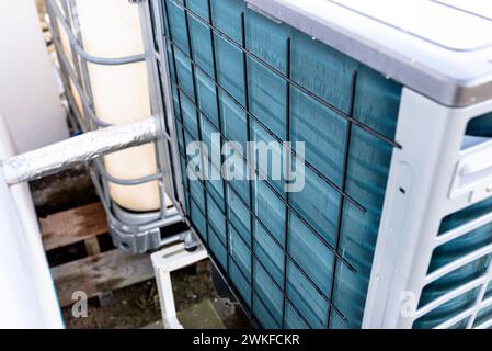 Unité extérieure d'une pompe à chaleur à air de faible puissance située devant la maison. Banque D'Images