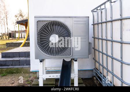 Unité extérieure d'une pompe à chaleur à air de faible puissance située devant la maison. Banque D'Images