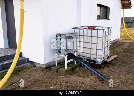 Unité extérieure d'une pompe à chaleur à air de faible puissance située devant la maison. Banque D'Images