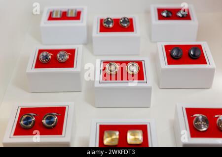 Boîtes avec boutons de manchette sur l'étagère dans la boutique. Ensemble de superbes boutons de manchette en platine ou dorés, formes diverses. Boutons de manchette en caisses en bois sur pa en velours noir Banque D'Images