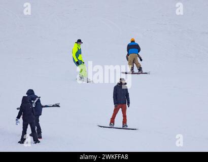 Les snowboarders descendent les pentes enneigées et profitent d'une belle journée. Banque D'Images