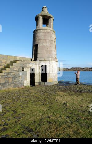 Port Logan Galloway Écosse - Un visiteur regarde le quai et le clocher du petit village qui a été conçu par Thomas Telford Banque D'Images
