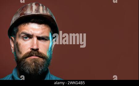 Gros plan portrait d'un constructeur masculin sérieux dans un casque de protection. Architecte barbu ou ingénieur en casque de construction. Beau mécanique ou Banque D'Images