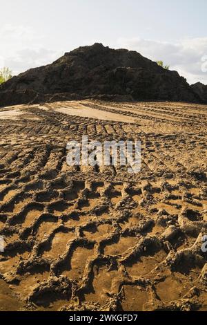 Traces de pneus lourds et monticule de sable mélangé avec du sol dans un bac à sable commercial. Banque D'Images