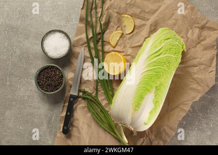 Chou chinois frais, citron, oignon vert et épices sur table gris clair, pose à plat Banque D'Images