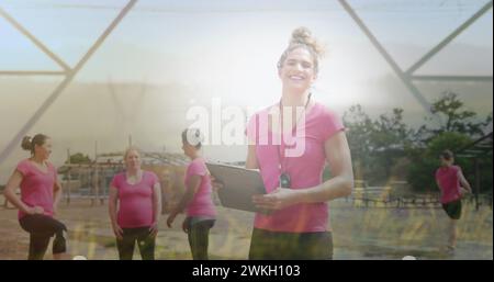 Image de l'herbe sur diverses femmes et entraîneur à la course d'obstacles Banque D'Images