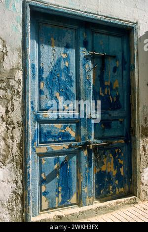 Essaouira, Maroc. Une porte en bois battu par les intempéries dans la médina ou le vieux quartier Banque D'Images