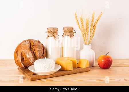 Un fromage différent, du pain, du fromage cottage, de la crème sure, du lait dans des bouteilles sur un comptoir en bois. Concept de la fête juive de Shavouot. Vue de face Banque D'Images