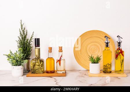 Beaucoup de bouteilles d'huile différentes de différentes sortes sur le comptoir en marbre de la cuisine. Plantes d'intérieur en pot. Espace de rangement compact. Fond de cuisine élégant Banque D'Images