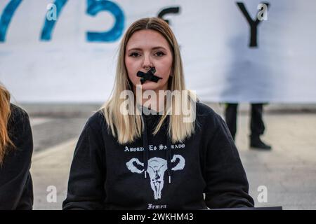 Madrid, Espagne. 20 février 2024. Une activiste avec du ruban adhésif sur sa bouche participe à un rassemblement contre la loi du bâillon. Dans le cadre de la "Journée internationale de la justice sociale", une concentration de différents groupes de mouvements sociaux (Femen Espagne, extinction Rebelion Madrid, Rebelion CientÍfica et plus) a eu lieu sur la Plaza de Colón de Madrid. Ils ont exigé l'abrogation de toutes les lois répressives et la suspension de toutes les sanctions imposées à l'exercice de l'activisme pacifique. Crédit : SOPA images Limited/Alamy Live News Banque D'Images