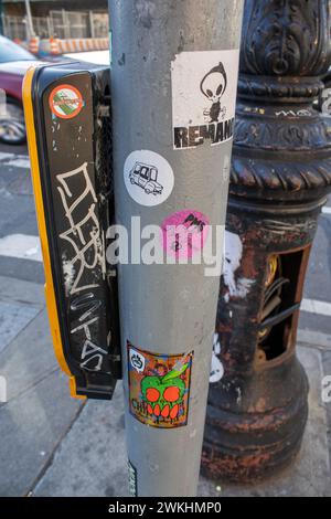 Les autocollants colorés recouvrant un poteau de rue à New York, USA Banque D'Images