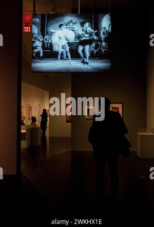 New York, New York, États-Unis. 20 février 2024. Un visiteur regarde un clip vidéo de la performance de Duke Ellington Orchestra et des danseurs du Cotton Club à la prochaine exposition Harlem Renaissance au Metropolitan Museum de New York lors d'une avant-première de presse le 20 février 2024. L'exposition présente le premier mouvement afro-américain d'art moderne international atteignant l'autre côté de l'Atlantique et influençant certains artistes célèbres tels que Munch, Picasso et Matisse. (Crédit image : © Lev Radin/ZUMA Press Wire) USAGE ÉDITORIAL SEULEMENT! Non destiné à UN USAGE commercial ! Banque D'Images