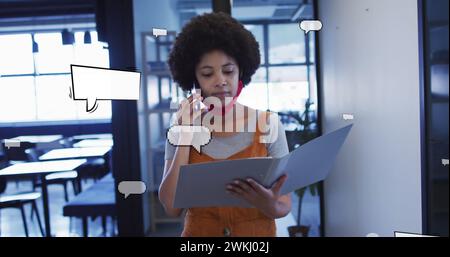 Image de bulles de discours sur une femme d'affaires afro-américaine parlant sur smartphone Banque D'Images