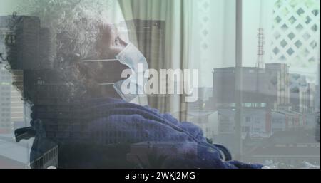 Image d'un paysage urbain au-dessus d'une femme afro-américaine handicapée assise en fauteuil roulant Banque D'Images