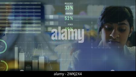 Image de diagrammes flottants, de cercles, de carte du monde et de traitement de données sur le docteur féminin biracial exa Banque D'Images
