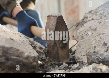 Homme brisant des pierres avec un marteau de forge à l'extérieur, gros plan Banque D'Images